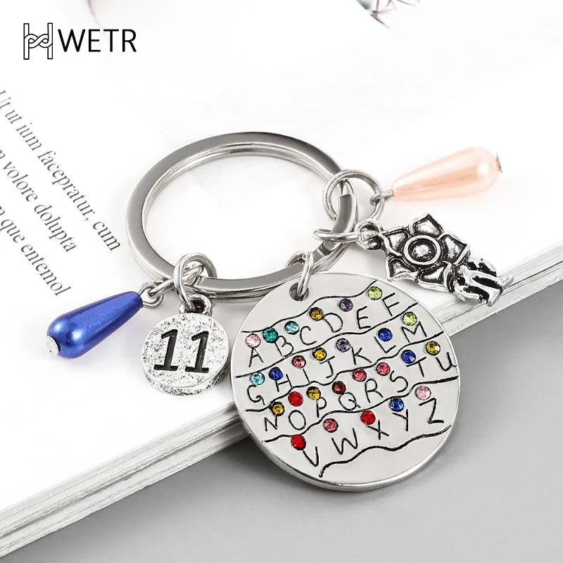 Llavero con el alfabeto inglés de la serie de televisión Strange Things para hombres y mujeres, plateado, colorido, para mochila, accesorio para llave de coche.